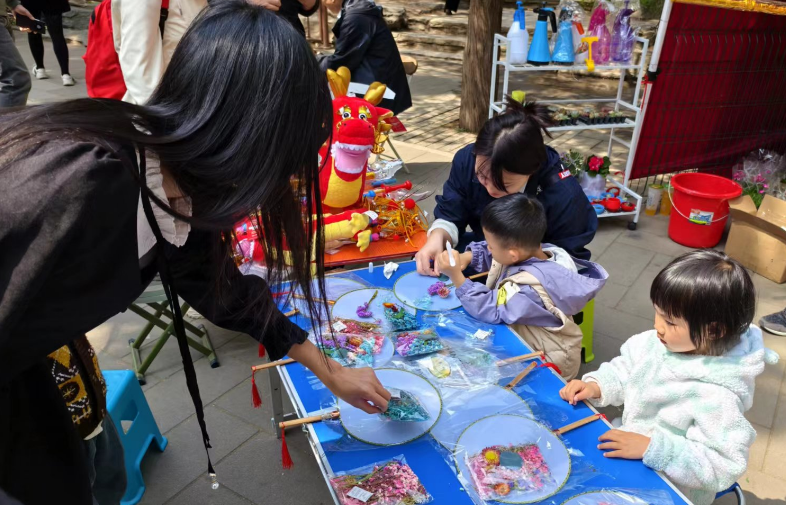 北京陶然亭公园开设的陶然市集上，小游客们正在体验画扇面。记者 乔业琼摄